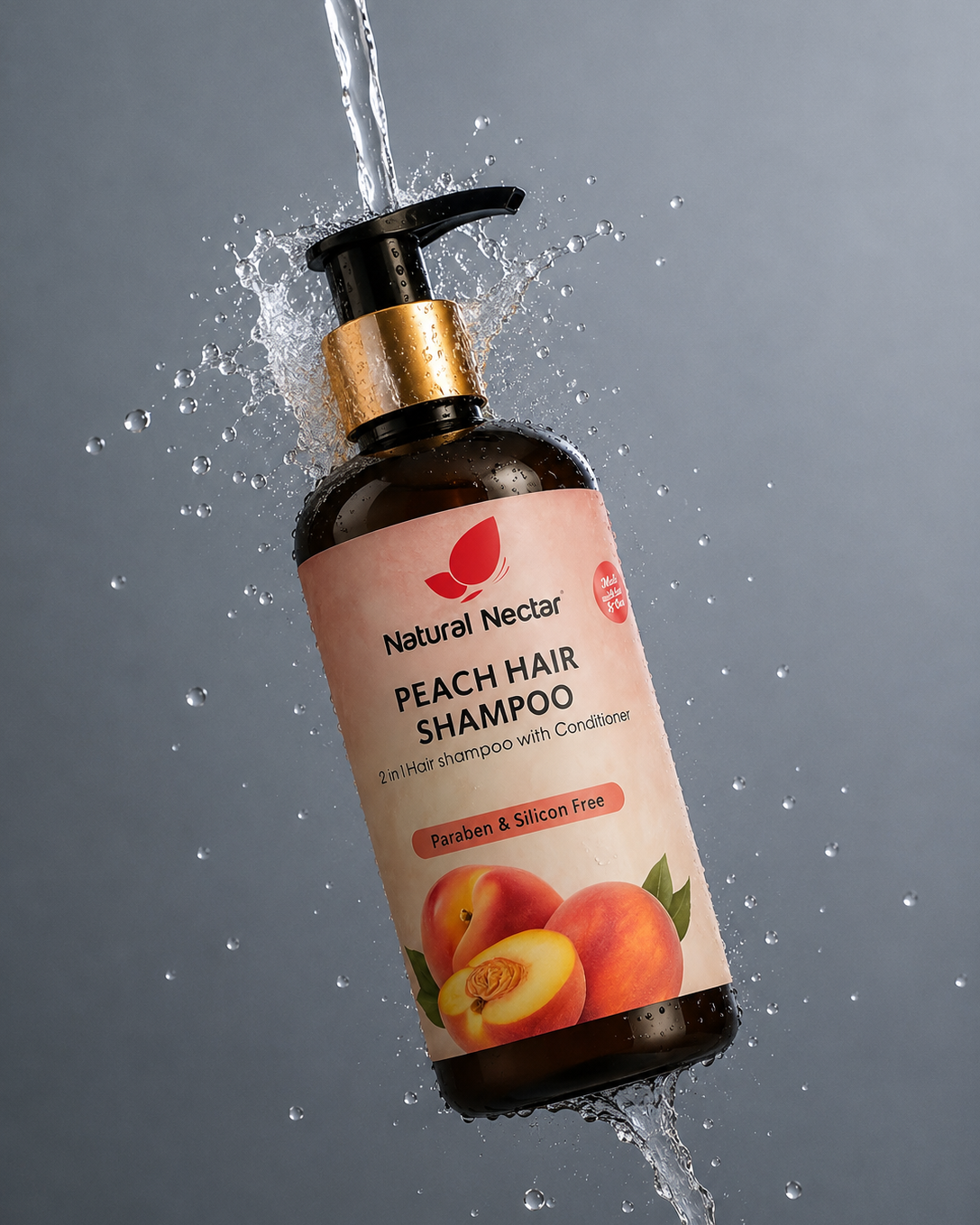 A bottle of Natural Nectar Peach Hair Shampoo floating in mid-air with water spraying around it against a dark gray background. The bottle is dark amber brown with a gold collar and a pink label featuring peach illustrations.