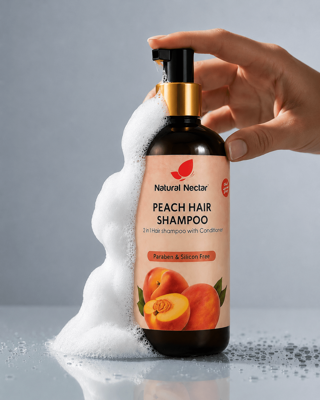 A hand holds a pump bottle of Natural Nectar Peach Shampoo with white foam dripping from the nozzle onto a grey surface.